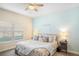 Bright bedroom featuring light blue walls, ceiling fan and floral bedding at 1161 Trappers Trail Loop, Davenport, FL 33896