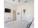 Bright bedroom featuring white walls, ceiling fan and gray and white striped bedding at 1161 Trappers Trail Loop, Davenport, FL 33896