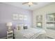 A serene bedroom with light purple walls, comfortable bed, and bright windows offering outdoor views at 1161 Trappers Trail Loop, Davenport, FL 33896