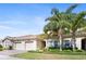 Attractive home exterior with lush landscaping, mature palm trees, and a tiled roof at 1161 Trappers Trail Loop, Davenport, FL 33896