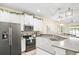 Bright, open kitchen featuring white cabinets, stainless steel appliances, and quartz countertops at 1161 Trappers Trail Loop, Davenport, FL 33896