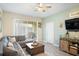 A charming living room showcases a gray sectional, a stylish wood coffee table, and sliding glass doors to a patio at 1161 Trappers Trail Loop, Davenport, FL 33896