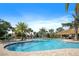 Beautiful community pool featuring a tropical landscape, lounge chairs and a tiki hut at 1161 Trappers Trail Loop, Davenport, FL 33896