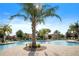 Community pool featuring a lush landscape, lounge chairs and umbrella at 1161 Trappers Trail Loop, Davenport, FL 33896