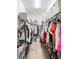 Functional walk-in closet with clothes hanging from multiple racks and shoe storage at 1161 Trappers Trail Loop, Davenport, FL 33896