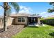 Inviting backyard with a patio, comfortable seating, lush lawn and mature landscaping at 11908 Delfina Ln, Orlando, FL 32827