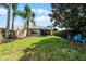 Landscaped backyard featuring lush green grass, palm trees, and outdoor seating area for relaxing at 11908 Delfina Ln, Orlando, FL 32827