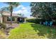 Relaxing backyard featuring lush green grass and outdoor seating area with mature trees at 11908 Delfina Ln, Orlando, FL 32827