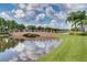 Scenic community bridge over a serene lake, complemented by palm trees and lush landscaping, offering a tranquil view at 11908 Delfina Ln, Orlando, FL 32827