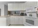 White kitchen featuring cabinetry and countertops, tile backsplash, and modern appliances at 11908 Delfina Ln, Orlando, FL 32827