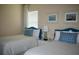 Bright bedroom with two beds, blue accents, and serene decor creating a calming retreat at 12030 Waterstone Loop Dr, Windermere, FL 34786