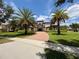 A stately home with a red-brick driveway, palm trees, and manicured landscaping on a sunny day at 12030 Waterstone Loop Dr, Windermere, FL 34786