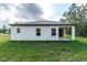 Exterior view of the house showcasing the well-manicured backyard and covered patio at 13068 Sw 36Th Ct, Ocala, FL 34473