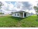 Backyard view of the home with a well-maintained lawn, covered patio, and lush landscaping at 13068 Sw 36Th Ct, Ocala, FL 34473