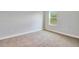 This bedroom has neutral carpet, base trim, and a window view at 13068 Sw 36Th Ct, Ocala, FL 34473