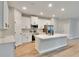 The stunning kitchen offers stainless appliances, sleek white cabinets, quartz counters, and lots of natural light at 13068 Sw 36Th Ct, Ocala, FL 34473