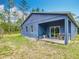 Back exterior of blue single-story house with a covered patio and view of the backyard at 13297 Sw 69Th Pl, Ocala, FL 34481