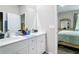 Bathroom with dual sinks, white cabinets and granite counter tops, and a view to bedroom at 13297 Sw 69Th Pl, Ocala, FL 34481