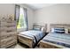 Bedroom featuring two beds with stylish blue striped bedding and a window with patterned curtains at 13297 Sw 69Th Pl, Ocala, FL 34481