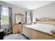 Bright bedroom features two windows, carpet and a decorative bed frame with a large mirror at 13297 Sw 69Th Pl, Ocala, FL 34481