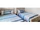 Cozy bedroom featuring rustic twin beds with blue striped bedding and wooden frames at 13297 Sw 69Th Pl, Ocala, FL 34481