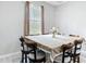 Bright dining room with a large window showcasing a green, wooded view and an 8 seat table at 13297 Sw 69Th Pl, Ocala, FL 34481