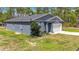 Charming single-story home with gray stucco and a well-manicured front lawn with an attached two car garage at 13297 Sw 69Th Pl, Ocala, FL 34481