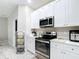 Modern kitchen boasts stainless steel appliances, ample white cabinetry, and stylish countertops at 13297 Sw 69Th Pl, Ocala, FL 34481
