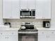 Bright kitchen features stainless steel appliances, white cabinets, and sleek countertops at 13297 Sw 69Th Pl, Ocala, FL 34481
