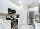 Modern kitchen with stainless steel appliances, sleek white cabinets, and stone countertops at 13297 Sw 69Th Pl, Ocala, FL 34481