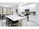 Modern kitchen island featuring quartz countertops, seating, and seamless flow into the dining area at 13297 Sw 69Th Pl, Ocala, FL 34481