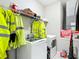 Laundry room with a new washer and dryer set, yellow safety vests and wire shelving at 13297 Sw 69Th Pl, Ocala, FL 34481