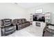 Cozy living room with leather seating, decorative shelving, and a decorative fireplace at 13297 Sw 69Th Pl, Ocala, FL 34481