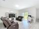 Neutral living room features recliners, a workstation, and sliding glass doors leading to backyard at 13297 Sw 69Th Pl, Ocala, FL 34481