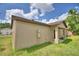 Exterior backyard view showcasing the lawn, beige siding, and architectural design of this single Gathering home at 1390 E Wabash St, Bartow, FL 33830