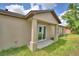 Exterior backyard view showcasing the covered patio, sliding glass door, beige siding, and architectural design at 1390 E Wabash St, Bartow, FL 33830