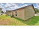 Exterior backyard view showcasing the HVAC unit, beige siding, and architectural design of this single Gathering home at 1390 E Wabash St, Bartow, FL 33830