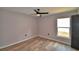 Clean and airy bedroom featuring wood-look flooring, a ceiling fan, and a window for natural light at 1390 E Wabash St, Bartow, FL 33830