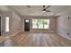 Bright and open living room, with windows, a ceiling fan, fresh paint, and wood floors at 1390 E Wabash St, Bartow, FL 33830