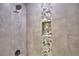 Close up on the modern shower, with gray tile and mosaic accents around a recessed shelf at 1390 E Wabash St, Bartow, FL 33830