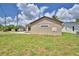 Exterior side view showcasing mailbox, window, freshly cut lawn, and beige siding at 1390 E Wabash St, Bartow, FL 33830