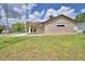 Exterior side view showcasing mailbox, window, freshly cut lawn, and beige siding at 1390 E Wabash St, Bartow, FL 33830