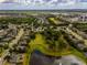 Neighborhood aerial view showcases a community surrounded by trees, adjacent to a lake and green space at 14003 Hampshire Bay Cir, Winter Garden, FL 34787