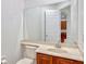 Bathroom features a toilet, vanity with sink, and large mirror; open door shows view into kitchen at 14003 Hampshire Bay Cir, Winter Garden, FL 34787