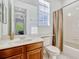 Bathroom featuring shower/tub combo, dark wood vanity, and a view into an adjacent bedroom at 14003 Hampshire Bay Cir, Winter Garden, FL 34787