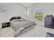 Cozy bedroom features a large window, neutral carpet, and a dark wood dresser and nightstand at 14003 Hampshire Bay Cir, Winter Garden, FL 34787