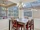 Elegant dining area features a chandelier and views of the screened-in patio and pool at 14003 Hampshire Bay Cir, Winter Garden, FL 34787