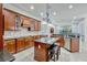 Large kitchen with dark cabinets, granite counters, a central island, and a view into the living room at 14003 Hampshire Bay Cir, Winter Garden, FL 34787