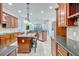 Open kitchen with granite countertops, wood cabinetry, an island, and stainless steel appliances at 14003 Hampshire Bay Cir, Winter Garden, FL 34787