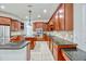 Gourmet kitchen featuring dark cabinetry, granite countertops, a center island, and stainless steel appliances at 14003 Hampshire Bay Cir, Winter Garden, FL 34787